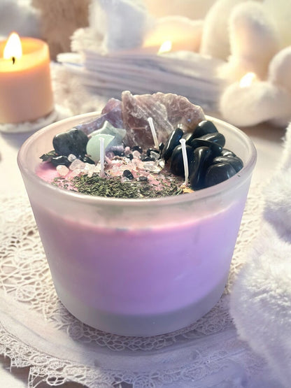 JoyfulBliss Co. Protect + Deflect soy ritual candle topped with crystals and herbs in a frosted glass jar