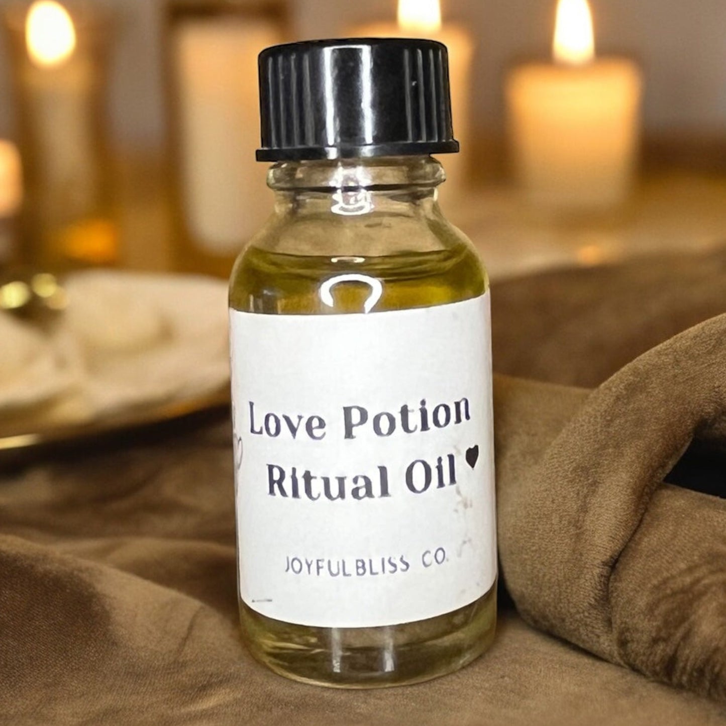JoyfulBliss Co. Love Potion Ritual Anointing Oil in a 10ml glass bottle with a black cap on a brown velvet cloth.