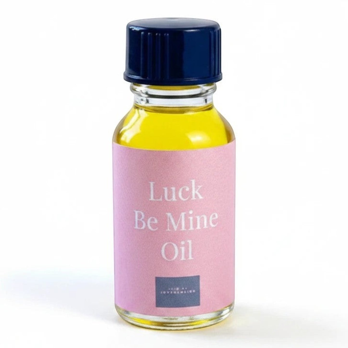 JoyfulBliss Co. Luck Be Mine ritual oil in a glass bottle with a pink label and dark blue cap for manifestation.