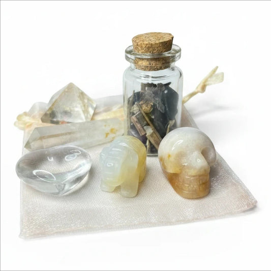 JoyfulBliss Co. Manifesting Mojo Bag with crystals, spell jar, and carved stone elephant and skull on organza pouch.