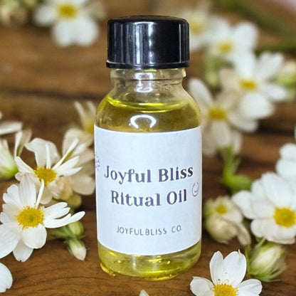 JoyfulBliss Co. Joyful Bliss Ritual Anointing Oil in a 10ml glass bottle surrounded by white daisy flowers