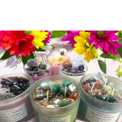 JoyfulBliss Co. ritual candles topped with healing crystals and herbs, displayed with vibrant flowers for energy renewal.