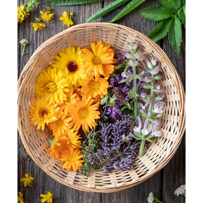 JoyfulBliss Co. ritual oil ingredients featuring fresh orange calendula, purple lavender, and sage in a woven basket