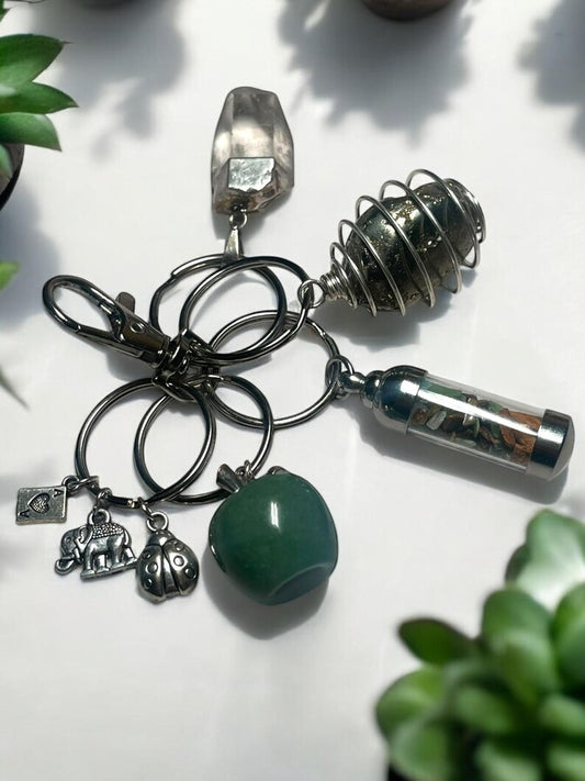 Abundance & Protection Crystal Keychain Set – Green Aventurine Apple, Pyrite Spiral, Smoky Quartz, Mini Gem Jar, and Lucky Charms