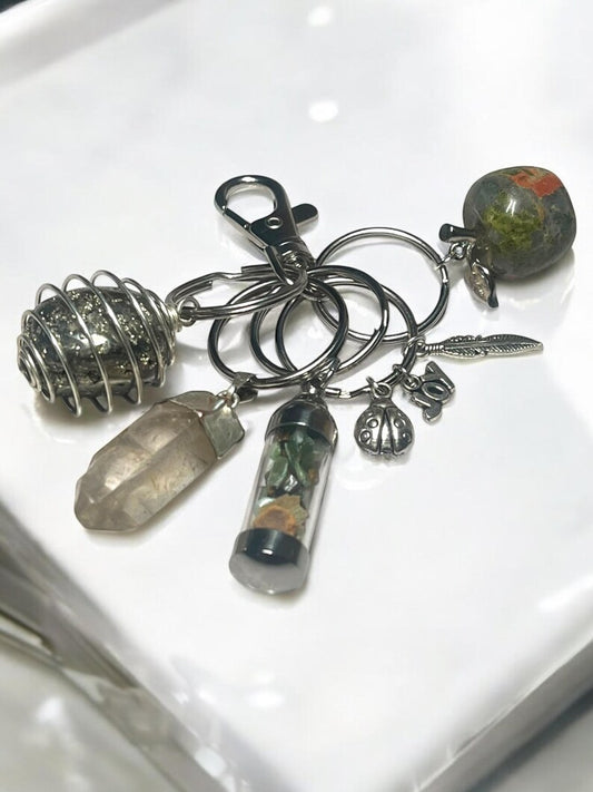 Grounding & Abundance Crystal Keychain Set – Pyrite Spiral, Smoky Quartz Point, Unakite Apple, Mini Gem Jar & Lucky Charms